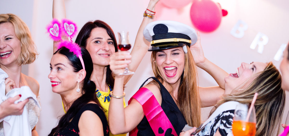 Cheerful bride and bridesmaids celebrating an unforgettable hen party with drinks